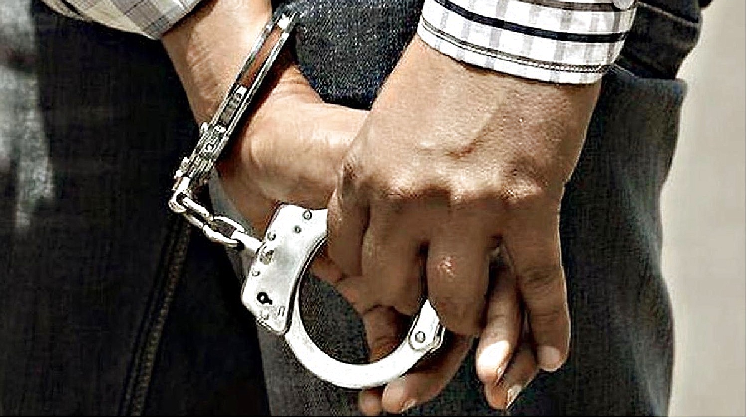 Arrested suspect shown in handcuffs