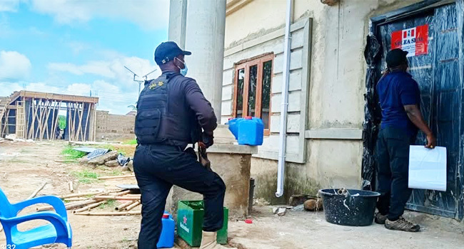 NDLEA personnel at the entrance to a property linked to the alleged Ebonyi methamphetamine laboratory